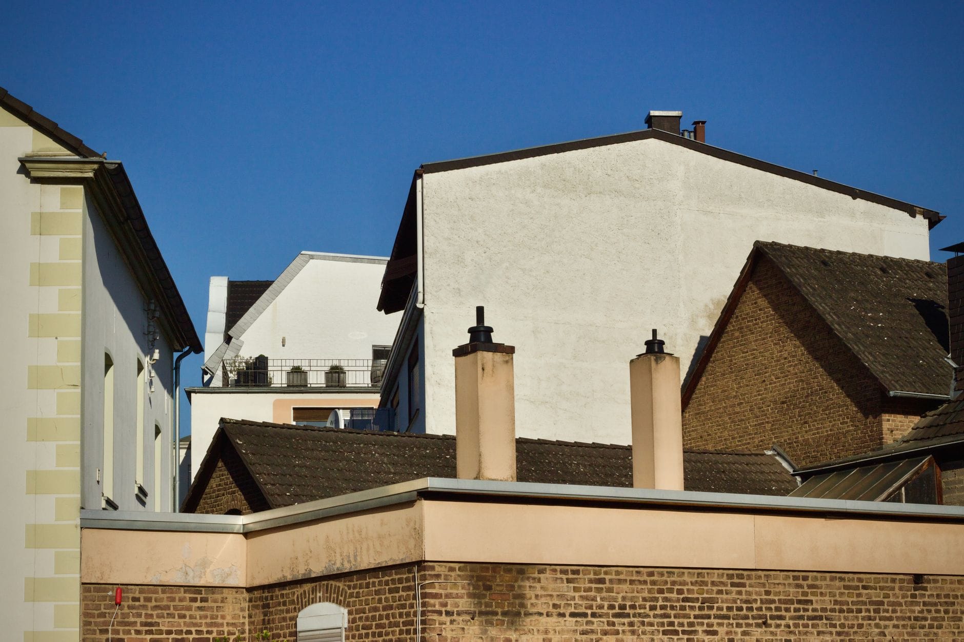 City architecture with diverse rooftops under a clear blue sky.